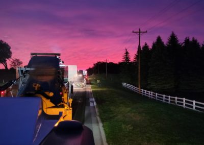 Road work beneath a pink sunset.
